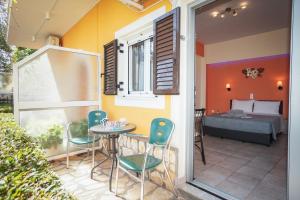 un patio avec une table, des chaises et un lit dans l'établissement Corfu Dream Fani, à Ýpsos