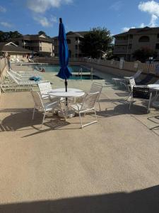 ein Tisch und Stühle mit einem blauen Sonnenschirm darauf in der Unterkunft Cypress Bay Getaway in Little River + 27 Fotos