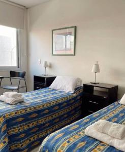 a hotel room with two beds and a mirror at Departamento en Alquiler en Carlos Paz in La Porteña