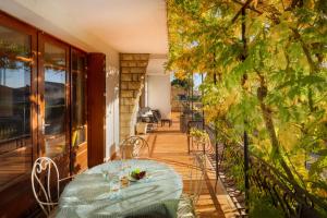 a table and chairs on a porch with a table and a balcony at L'Oustal 3 chambres avec grand jardin parking gratuit in Bram
