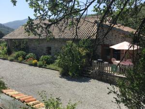 a stone house with a porch and a patio at Les Gîtes La Chareyre in Thueyts