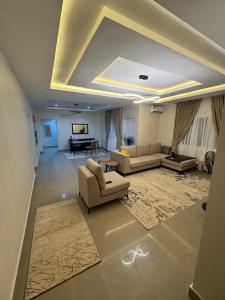 a large living room with couches and a table at Epic Apartment in Abuja