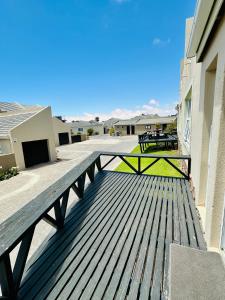 a wooden deck with a bench on the side of a building at Bay Breeze in Eros Airport