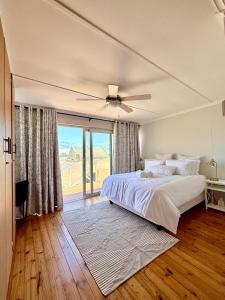 a bedroom with a bed and a ceiling fan at Bay Breeze in Eros Airport