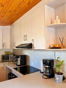 a kitchen with white cabinets and a counter top at Bay Breeze in Eros Airport