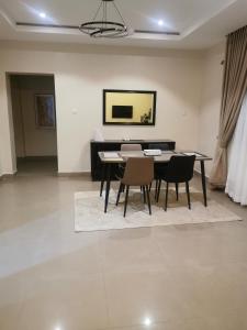 a dining room with a table and two chairs at Epic Apartment in Abuja