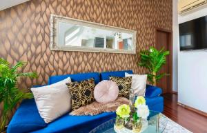 Velvet Sky Residence - InnerTown & Garage في بودابست: أريكة زرقاء في غرفة المعيشة مع مرآة