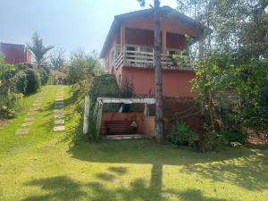 a red house with a grass yard in front of it at Marcos Araújo in Mairinque