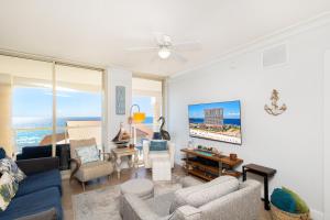 ein Wohnzimmer mit einem blauen Sofa und Stühlen in der Unterkunft Beach Club Gulf Front 3B Condo - 405 in Pensacola Beach