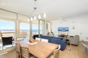 ein Esszimmer und ein Wohnzimmer mit Tisch und Stühlen in der Unterkunft Beach Club Gulf Front 3B Condo - 405 in Pensacola Beach