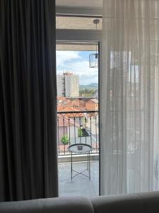 a window with a view of a balcony with a table at Star apartmani in Novi Pazar