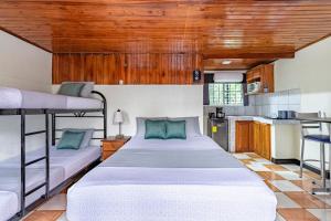 a bedroom with two bunk beds and a kitchen at Rio Danta in Fortuna