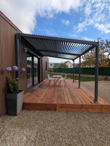 a wooden deck with a table and chairs on it at Gîte l'Hortensia Rose in Guémar