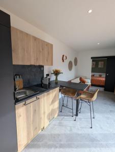 a kitchen with a sink and a table and chairs at Gîte l'Hortensia Rose in Guémar