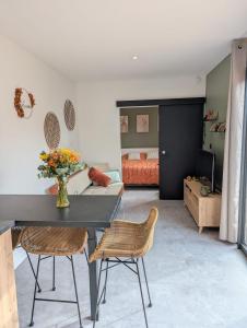 a living room with a table and chairs and a bedroom at Gîte l'Hortensia Rose in Guémar