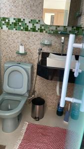 a bathroom with a green toilet and a sink at Casa temporada em Perocão in Guarapari +8 photos