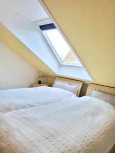 a bedroom with a large bed with a skylight at Seestern in Horumersiel
