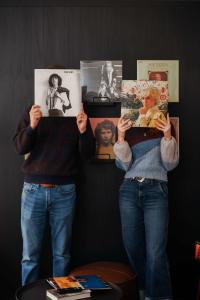 two people are holding up photos in front of a wall at Loft 308 - The William - Views over Carrigans in Birmingham