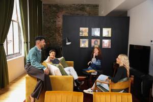 a group of people sitting in chairs in a room at Loft 308 - The William - Views over Carrigans in Birmingham