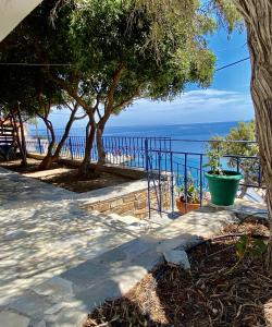 Une passerelle avec des arbres et l'océan en arrière-plan dans l'établissement Πέτρινη αυλή, Αρμενιστης Ικαρια, à Armenistis