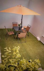 una mesa y sillas con sombrilla en una habitación en شقة الخالدية 3, en Medina