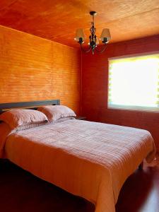 a bedroom with a large bed with a window at Cabaña Canelita in Cochrane