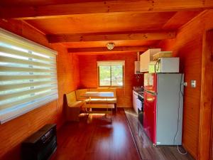 a small kitchen with a refrigerator and a table at Cabaña Canelita in Cochrane