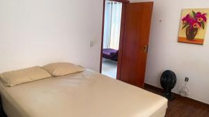 Un dormitorio con una cama y una puerta a un pasillo. en Conforto Total - Do café ao Sabão tudo incluso, en Varginha