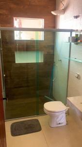 Un baño con inodoro y ducha de cristal. en Conforto Total - Do café ao Sabão tudo incluso, en Varginha