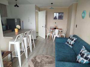 a living room with a blue couch and a table at Depto con vista al Volcán y piscina in Villarrica