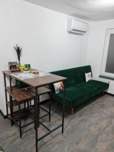 a living room with a green couch and a table at Studio Dimon in Pleven