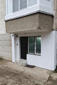 a white house with a black door and windows at Studio Dimon in Pleven