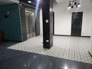 a bathroom with two black doors and a tile floor at Hotel Villa del Mar in Panama City