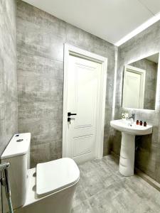 バクーにあるAlara Hotel INNの白いトイレと洗面台のあるバスルーム