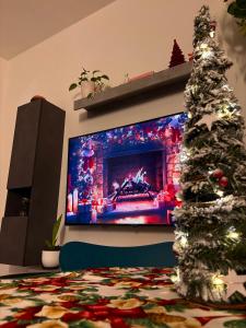 een woonkamer met een kerstboom voor een tv bij Al Kicco D'oro - Intero appartamento in Lido di Ostia