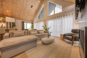 un ampio soggiorno con un divano e un tavolo di Kos - Domaine du Grand Portneuf - Spa Nature & Comfort a Pont-Rouge