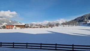 a snow covered field with a fence in the foreground at Studio Almwiese in Kaprun