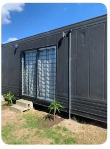 un edificio nero con finestra e alcune piante di Nido Urbano a Colonia del Sacramento