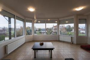 a living room with a table and large windows at Silyvo Cottage in Tríkala