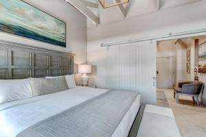 a bedroom with a large white bed and a chair at Parker's Collection - 4 Bedroom in Savannah +27 photos