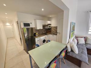 eine Küche und ein Wohnzimmer mit einer Couch und einem Tisch in der Unterkunft Tropikaz in Le Diamant