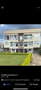 ein großes Apartmenthaus mit Rasen davor in der Unterkunft Les Jardins Prives Odza in Jaunde