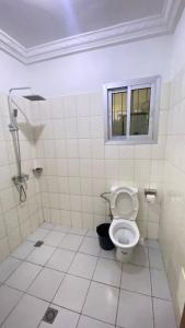 ein Badezimmer mit Toilette und Fenster in der Unterkunft Les Jardins Prives Odza in Jaunde + 24 Fotos