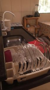 een afdruiprek gevuld met servies en keukengerei bij Casa Azul Completa in Palmeiras +9 foto's