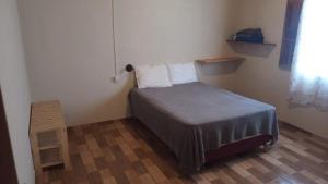 een kleine slaapkamer met een bed en een raam bij Casa Azul Completa in Palmeiras