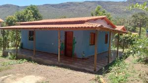 een klein blauw huis met een dak bij Casa Azul Completa in Palmeiras