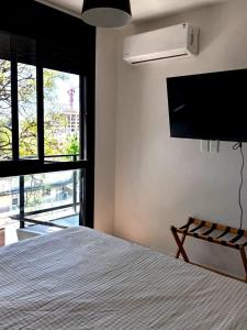 um quarto com uma cama e uma TV de tela plana em Modern apartment in Tres Cruces with amenities em Montevidéu
