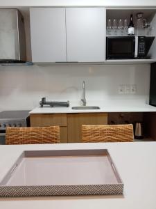 uma cozinha com armários brancos, uma pia e um micro-ondas em Modern apartment in Tres Cruces with amenities em Montevidéu