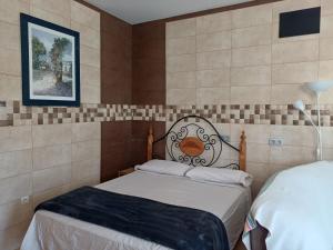 ein Schlafzimmer mit zwei Betten und einem Bild an der Wand in der Unterkunft Monte Campo Olivos Studio in Alhaurín de la Torre + 17 Fotos
