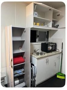 una piccola cucina con armadi bianchi e lavandino di Nido Urbano a Colonia del Sacramento Altre 4 foto